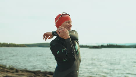 Female-Triathlete-in-Swimsuit-Warming-Up-on-Lakeshore